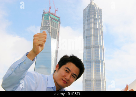 Imprenditore gesticolando sotto la Torre Jinmao,Shanghai, Cina Foto Stock
