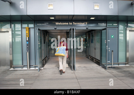 Benvenuti al Terminal 5 di Heathrow - lady passeggiando per ingresso Foto Stock