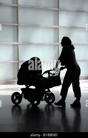 Silhouette di una madre con un contenuto della PRAM Foto Stock