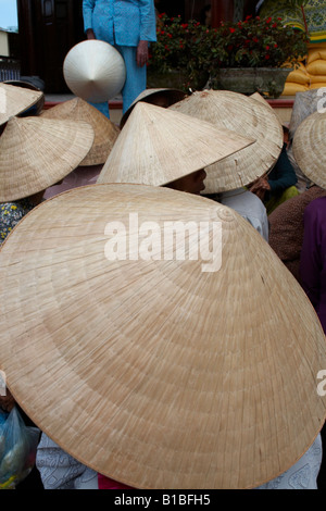 Donne che indossano tradizionale a forma di cono cappelli, Hoi An, Vietnam Foto Stock