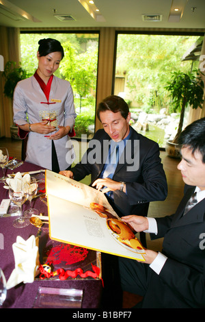 Imprenditori e imprenditrice di ordinare in hotel Ristorante Foto Stock