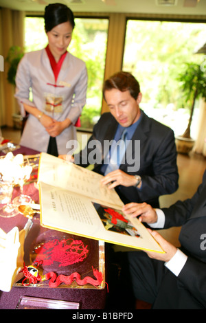 Imprenditori e imprenditrice di ordinare in hotel Ristorante Foto Stock