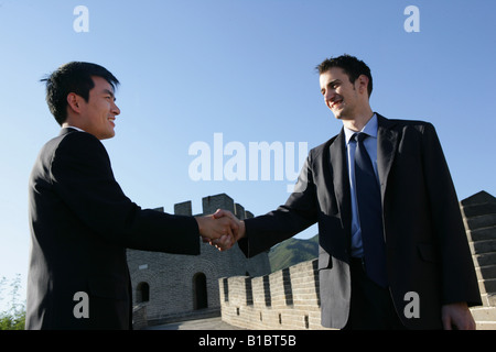 Due imprenditori lo handshaking sulla Grande Muraglia,Beijing, Cina Foto Stock