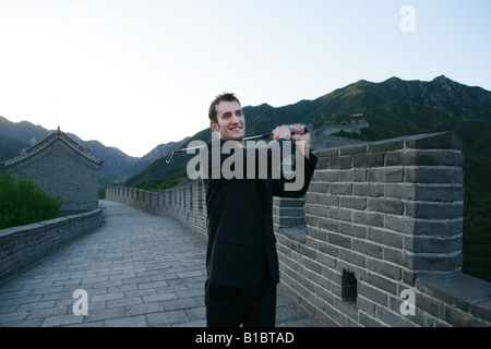 Imprenditore caucasico giocando a golf sul Grande Muro,Beijing, Cina Foto Stock