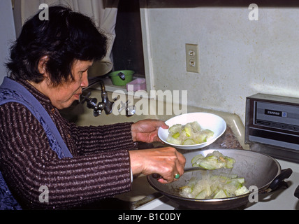 Donna cinese cuochi a Casa San Francisco California anziani senior preparazione alimentare nutrizione etnici wok Asiatici Foto Stock