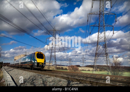 Un East Midlands meridiano treni treno passa nelle torri di raffreddamento e tralicci a E.ON Ratcliffe su Soar power station Foto Stock