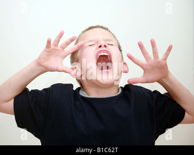 Ragazzo in studio urlando con un senso di frustrazione o rabbia Foto Stock