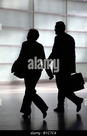 Silhouette di una donna e un uomo con valigetta Foto Stock