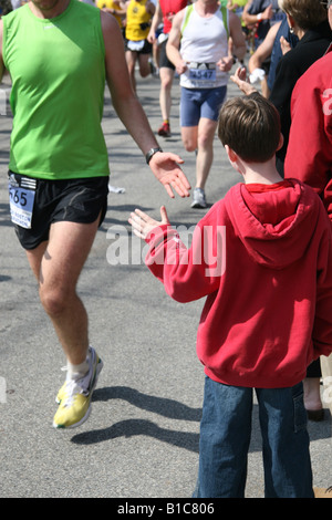 Un ragazzo dà un runner un alto cinque durante il 2008 Boston Marathon. 21 aprile 2008, Hopkinton, Massachusetts. Foto Stock
