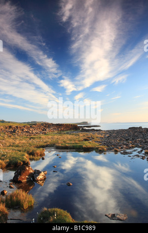 Nuvole riflettono in Rock Pool e la vista sulla baia di Staffin Isola di Skye in Scozia Foto Stock