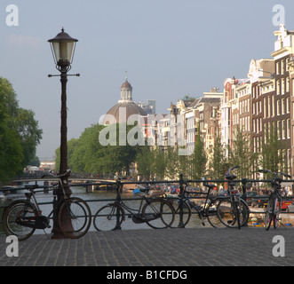 La Ronde Lutherse Kerk (distanza) sul canale Singel dal ponte Torensteeg, Amsterdam con le biciclette in primo piano Foto Stock