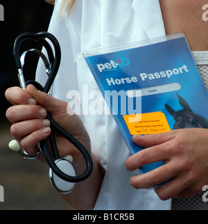 Veterinario azienda uno stetoscopio e ID Pet Passport di cavallo Foto Stock