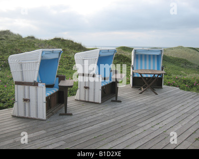 Spiaggia tradizionali cestelli (strandkorb) sul retro di una duna di sabbia a Sylt Germania Foto Stock