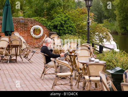 Uomo che legge il giornale e avente un drink presso l'Hotel Waveney,Beccles,Suffolk, Regno Unito Foto Stock