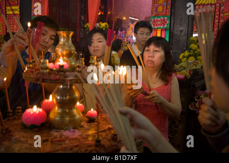 Adoratore femmina tempio di illuminazione candele presso il Tempio della Dea della Misericordia, durante il Capodanno cinese. Georgetown. Penang. Malaysia. Foto Stock