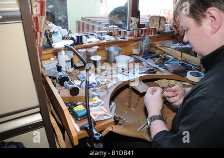 In Shetland, Scott Miller fa di gioielli in corrispondenza di un banco di lavoro nella cucina di casa sua. Foto Stock