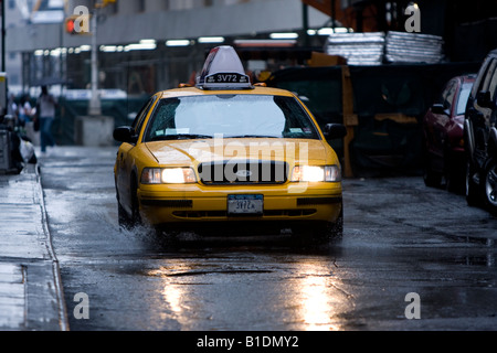 Una Ford Crown Victoria New York City taxi aziona verso il basso una pioggia inzuppato street a Manhattan. Foto Stock