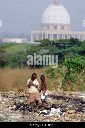 Due ragazzi di recupero attraverso il cestino in vista della Cattolica Romana, basilica di Notre Dame de la Paix, a Yamoussoukro, in Costa d Avorio Foto Stock