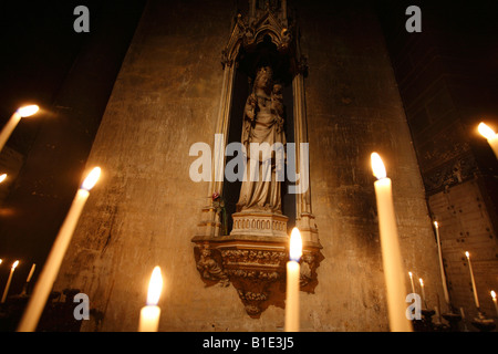 La statua della Vergine Maria con il bambino dietro candele nella Eglise Saint-Germain-des-Pres, Parigi, Francia Foto Stock