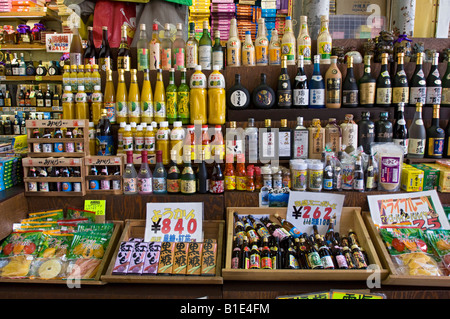 Bottiglie di Sake sul display in uno dei molti turisti in negozi di souvenir in Heiwa Dori mercato. Naha, Okinawa, in Giappone Foto Stock