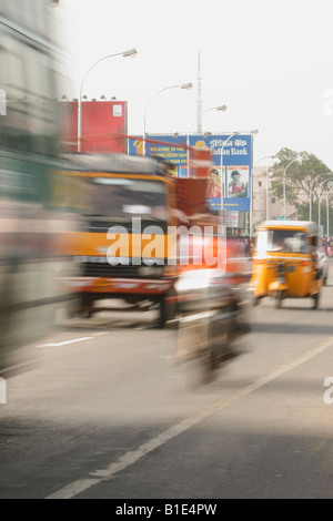 Un autobus, un autocarro e un'auto-rickshaw competere nel traffico e il trambusto della vita di strada a Chennai, India Foto Stock