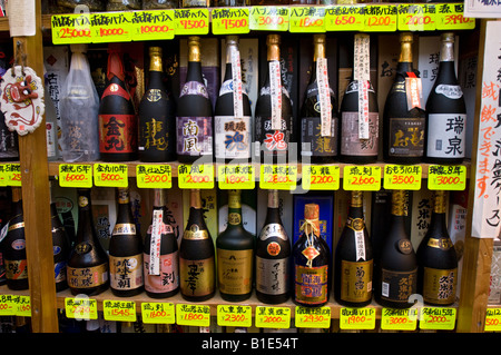 Bottiglie di Sake sul display in uno dei molti turisti in negozi di souvenir in Heiwa Dori mercato. Naha, Okinawa, in Giappone Foto Stock