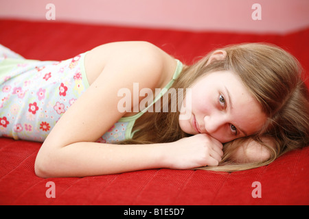 Triste ragazza preteen posa sul letto Foto Stock