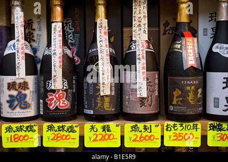 Bottiglie di Sake sul display in uno dei molti turisti in negozi di souvenir in Heiwa Dori mercato. Naha, Okinawa, in Giappone Foto Stock