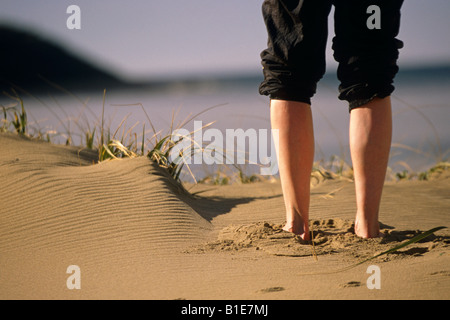 Femmina w/pantaloni arrotolato a piedi nudi in piedi in dune di sabbia mattinata baia poco profonda Terranova in Canada Foto Stock