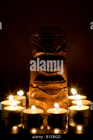 Tiki in legno circondata da candele Foto Stock