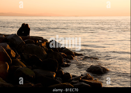 Paio di guardare il tramonto dal relitto Beach, Vancouver, Canada Foto Stock