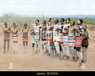 Karo Men dance in linea da saltare in aria in alto, gambe dritte. Anche mentre balli, ognuno di essi conservare loro Sgabelli in legno Foto Stock