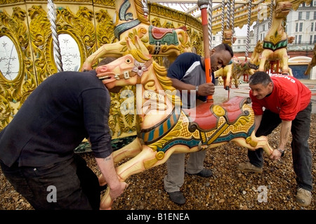 Fiera dei lavoratori assemblare gallopers per Owen Smith e del Figlio sulla giostra il Brighton Sea Front pronto per la nuova stagione Foto Stock