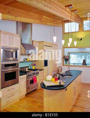 Cucina a vista di un residence contemporaneo con lavori in legno di acero e soffitto con travi a vista, Anchorage in Alaska. Foto Stock