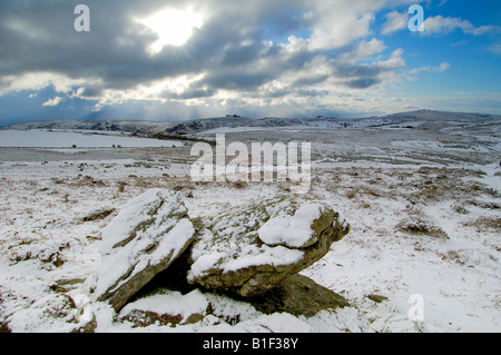 Neve pesante vicino Chinkwell Tor sul Parco Nazionale di Dartmoor con due massi di granito in primo piano e un cielo tempestoso Foto Stock