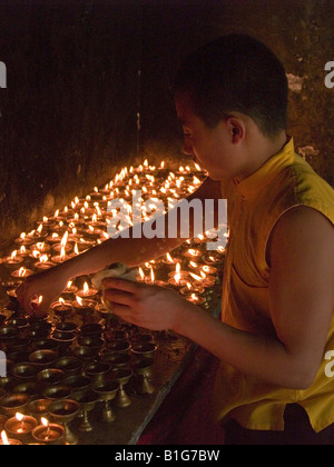 Monaco burro di illuminazione candele ad un monastero tibetano in Sikkim Foto Stock