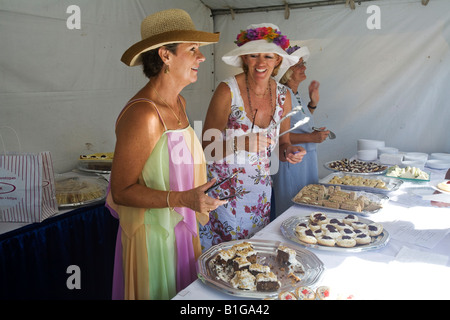 Tre donna servire torte durante un tradizionale tè inglese party in English Harbour, Antigua Foto Stock