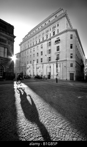 Ciclista crea un'ombra su piazza Foto Stock