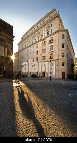 Ciclista crea un'ombra su piazza Foto Stock