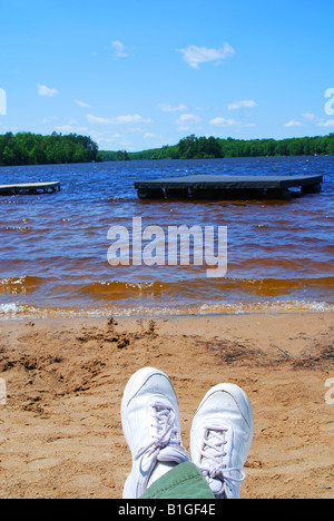 Relax su una pigra giornata estiva al lago. Troppo freddo per togliere le scarpe, abbastanza caldo per rilassarsi sotto il sole e la fresca brezza! Foto Stock