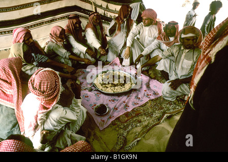 Arabia Saudita Empty Quarter. Al Murrah beduino attendere il segnale di start per scavare il cammello carne e riso Foto Stock