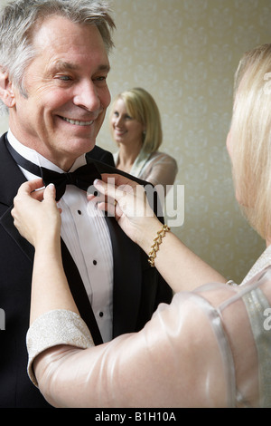 Donna di mezza età di legatura del marito il filtro bow tie Foto Stock