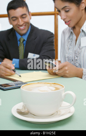 Business l uomo e la donna al cafe, focus sul cappuccino in primo piano Foto Stock