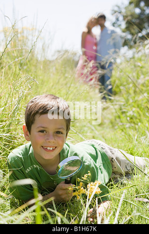 Un ragazzo in possesso di una lente di ingrandimento Foto Stock