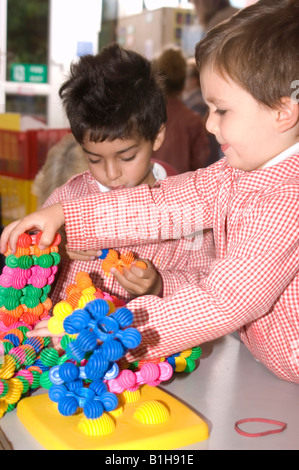 Giovani schoolboy giocare con un giocattolo di costruzione Foto Stock