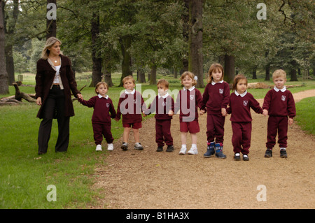 I bambini della scuola elementare nel parco con il loro insegnante Foto Stock