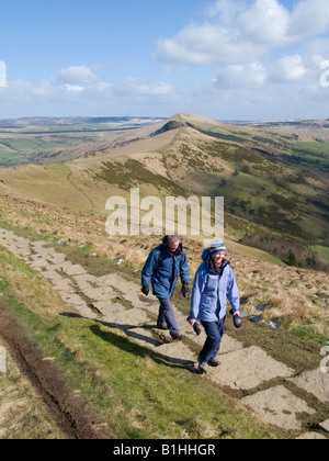 Giovane a piedi il sentiero pavimentato su Mam Tor, con una spolverata di neve nelle ombre. Parco Nazionale di Peak District. Regno Unito Foto Stock