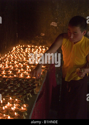 Monaco burro di illuminazione candele ad un monastero tibetano in Sikkim Foto Stock