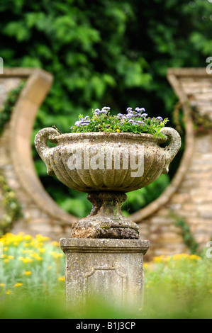 Un antico urna di pietra in un giardino murato con una forma a ferro di cavallo DESIGN FINESTRA REGNO UNITO Foto Stock