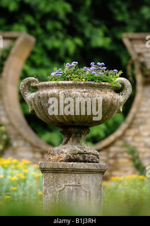 Un antico urna di pietra in un giardino murato con una forma a ferro di cavallo DESIGN FINESTRA REGNO UNITO Foto Stock